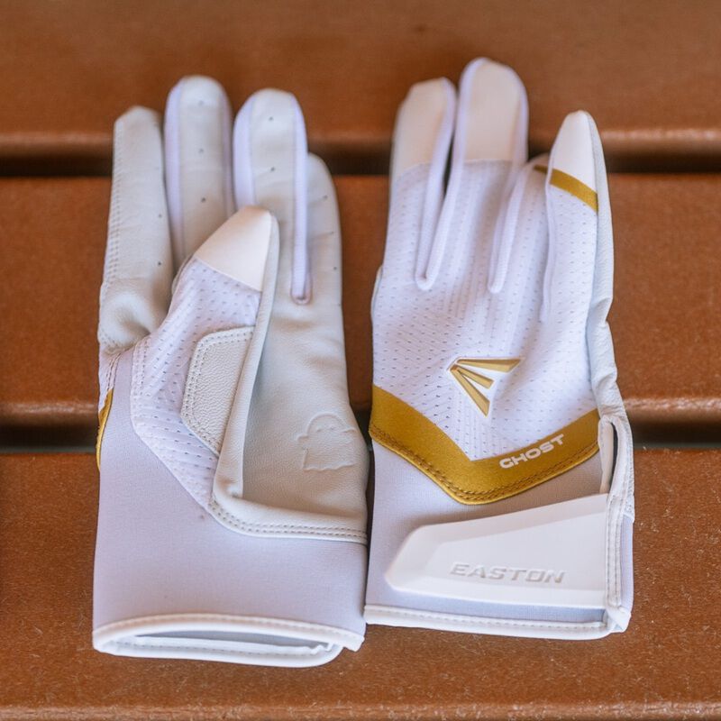 Picture of a pair of white Ghost Ethos Snowstorm fastpitch batting gloves on a bench