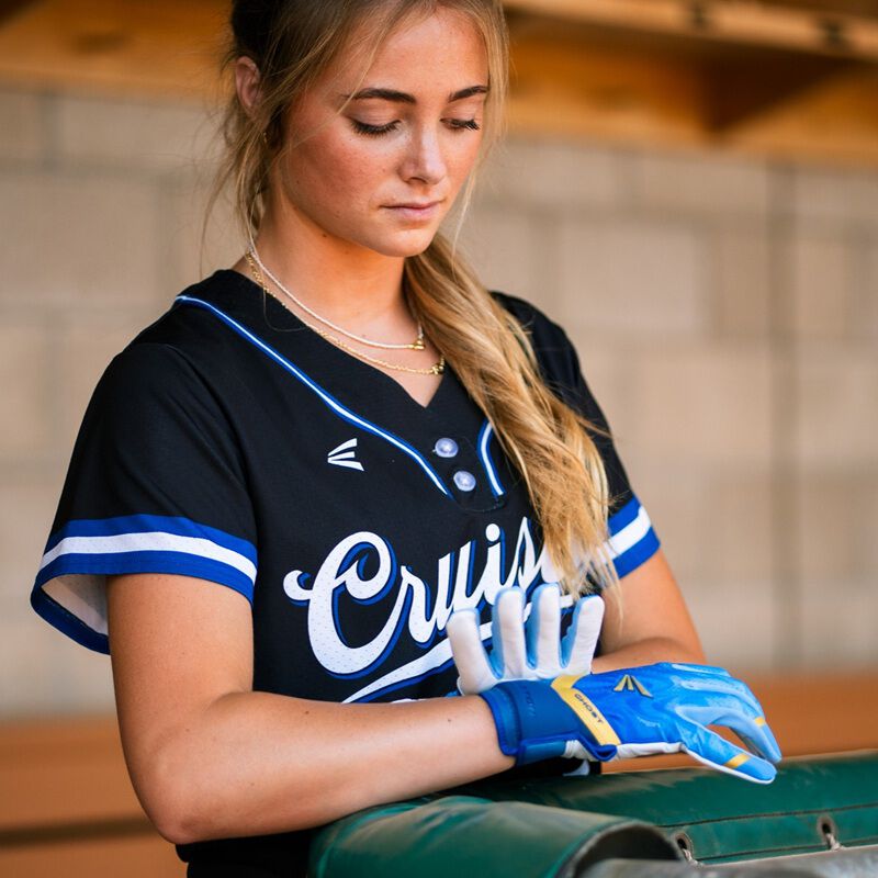 Picture of a player strapping the wrist strap on a blue Ghost Ethos Out of the Blue fastpitch batting gloves loading=