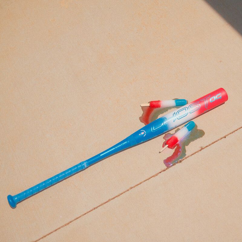 Picture of a red/white/blue Easton Ghost OG Rocket Pop fastpitch bat on the sidewalk with melted popsicles