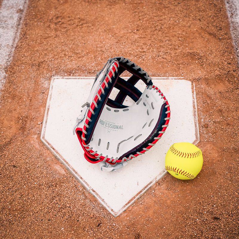 Picture of the palm of a red/white/navy Professional Collection Color Splash catcher's mitt with a ball on home plate