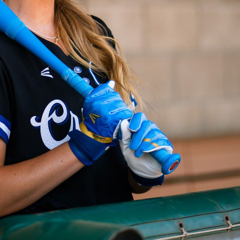 Picture of a player holding a bat wearing a pair of blue Ghost Ethos Out of the Blue fastpitch batting gloves loading=