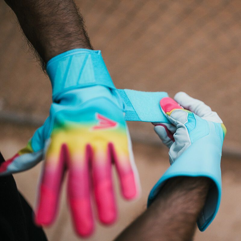 A player strapping on an Eason Walk-Off Ethos Locked-In Fire batting glove