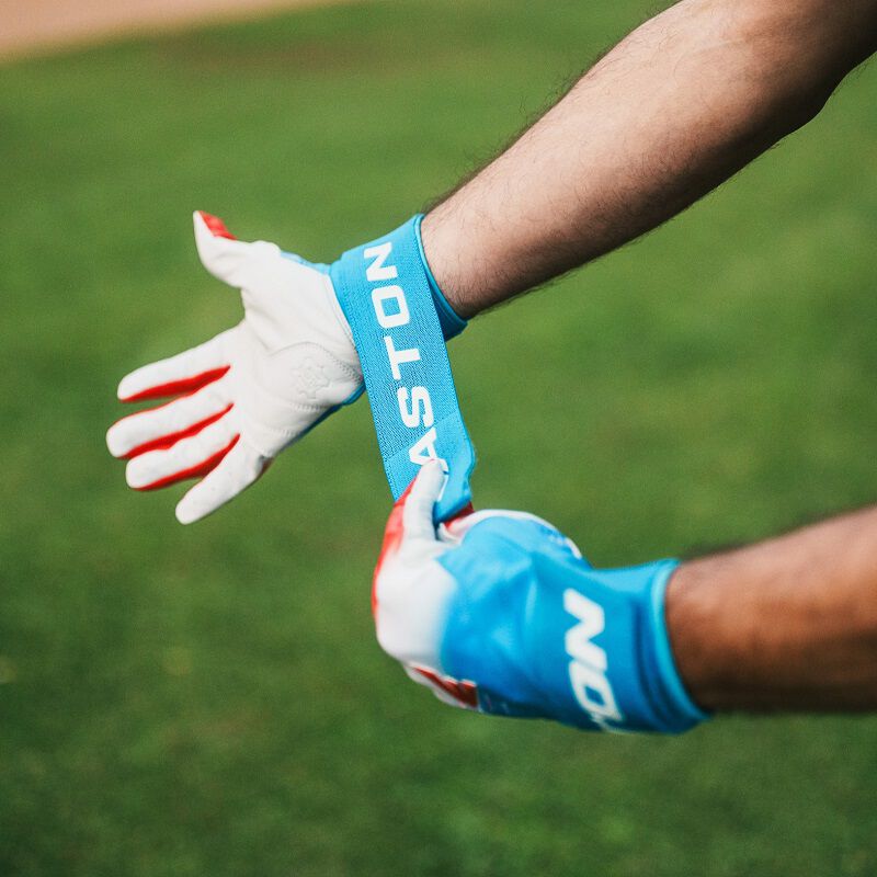 A player adjusting the long strap on an Easton Walk-Off Ethos Locked-In Rocket Pop batting glove