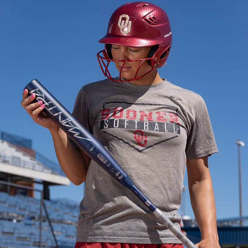 A picture of Oklahoma softball player Jayda Coleman holding and looking at a 2025 Mantra bat