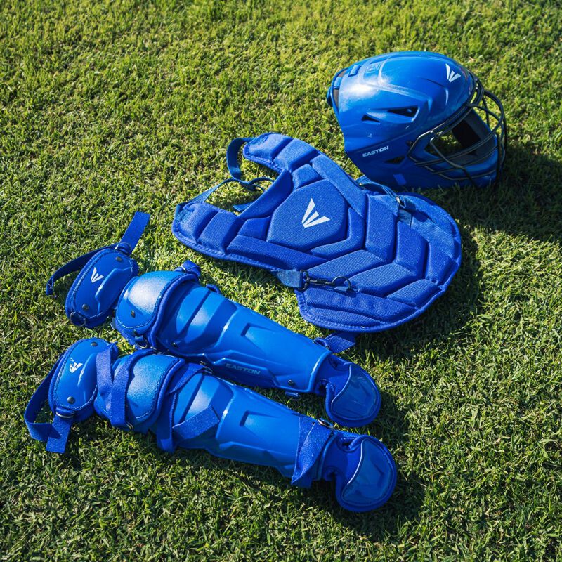 A royal Easton Black Magic 3.0 youth catcher's set laying on grass