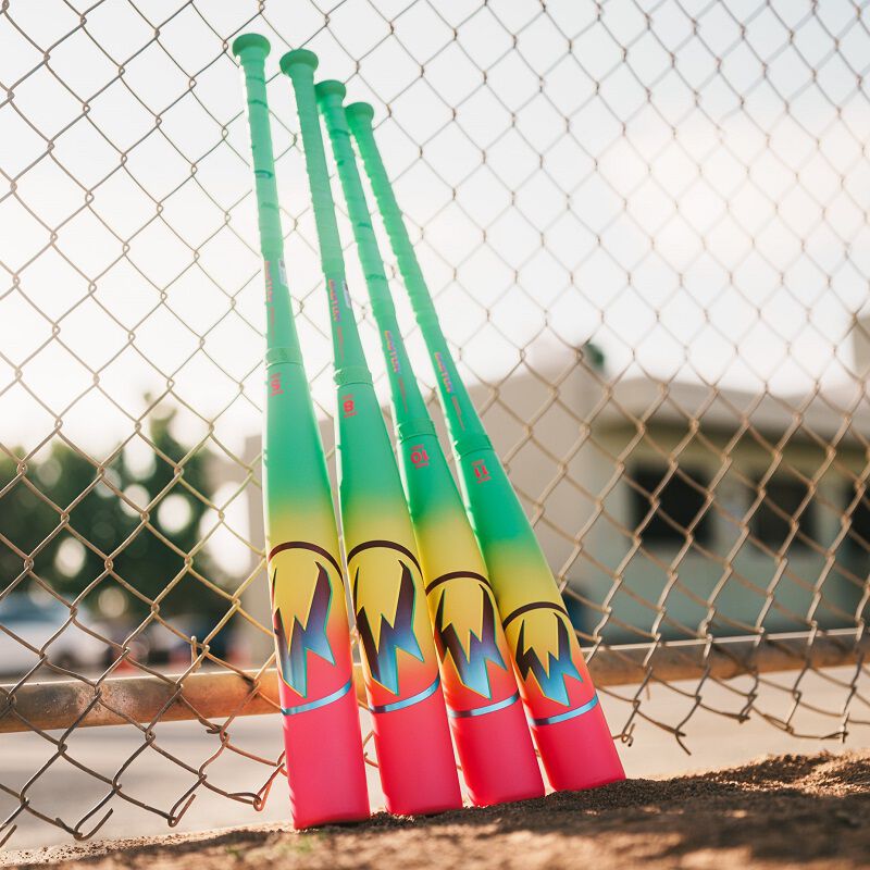 Picture of four 2026 Easton Hype Fire USA Baseball bats leaning against a fence