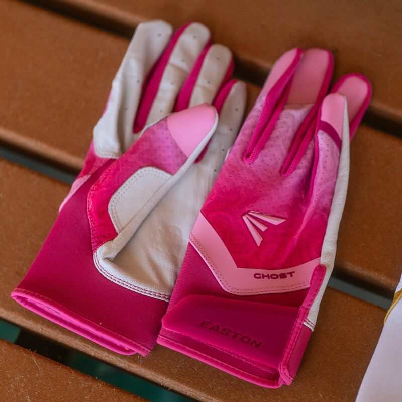 Picture of a pair of pink Ghost Ethos Strawberry Glow fastpitch batting gloves on a bench