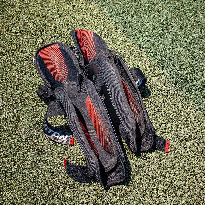 Inside padding of a pair of Hellcat Mojo leg guards on a field - SKU: HELMOLG loading=