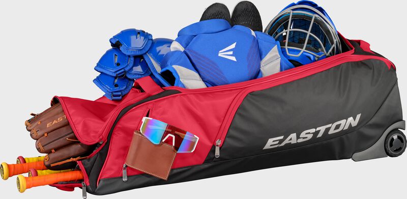 A red dugout wheeled bag filled with gear