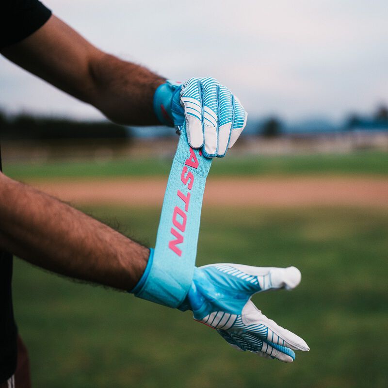 A player pulling the long strap of an Easton Walk-Off Ethos Locked-In Pool Party batting glove loading=
