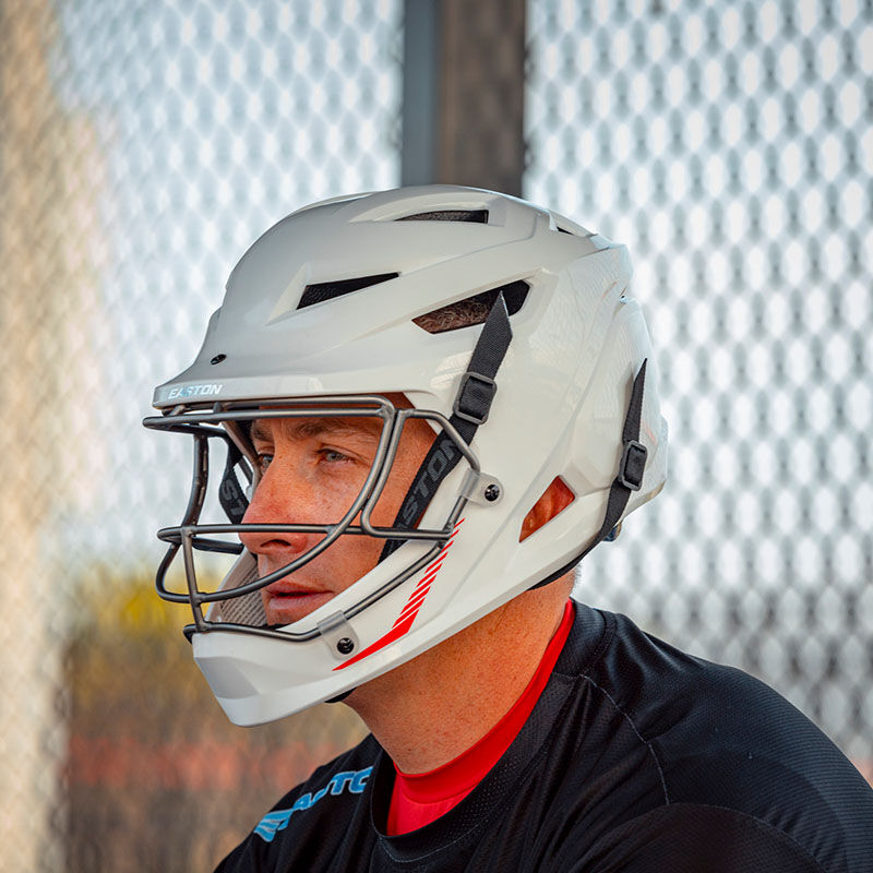 A player wearing a white Hellcat slowpitch fielding helmet in a dugout - SKU: EHCATH loading=