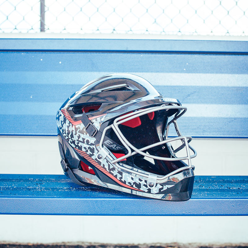 A black Easton Hellcat pitcher's helmet on the bench in a dugout - SKU: HELMOSPH loading=
