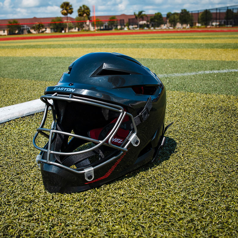 A black Hellcat slowpitch fielding helmet on a field - SKU: EHCATH