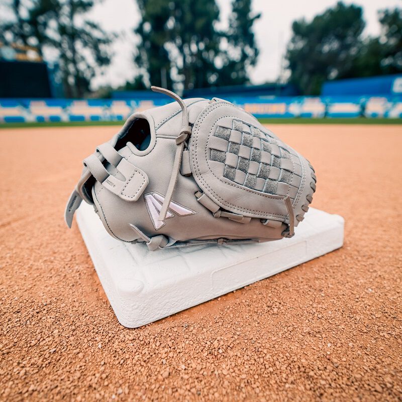 A gray Easton Professional Collection Color Splash glove on top of a base on a field