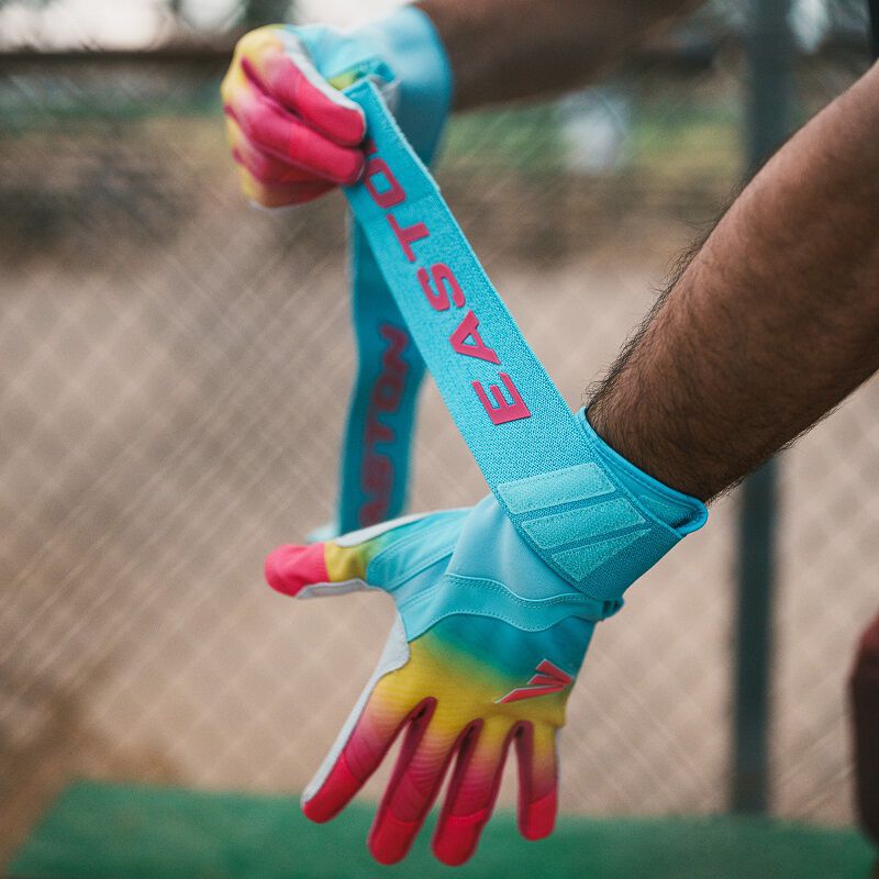 A player pulling the long strap on an Eason Walk-Off Ethos Locked-In Fire batting glove