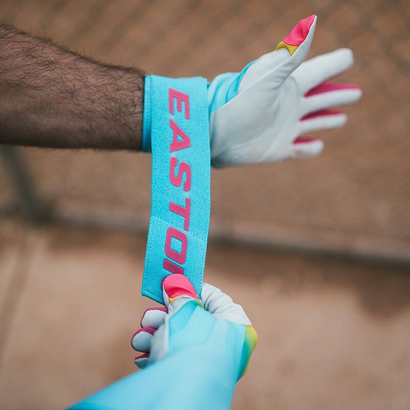 A player adjusting the long wrist strap of a Eason Walk-Off Ethos Locked-In Fire batting gloves loading=