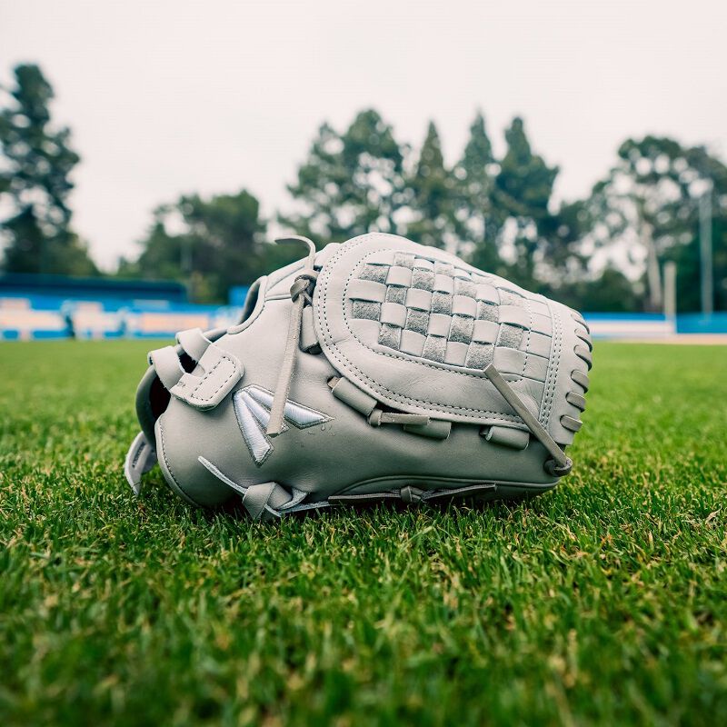 A gray Professional Collection Color Splash 12" fastpitch glove on a field