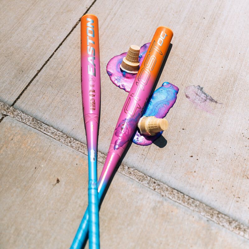 Picture of two Easton Ghost OG Rainbow sherbet fastpitch bats on sidewalk with melted sherbet
