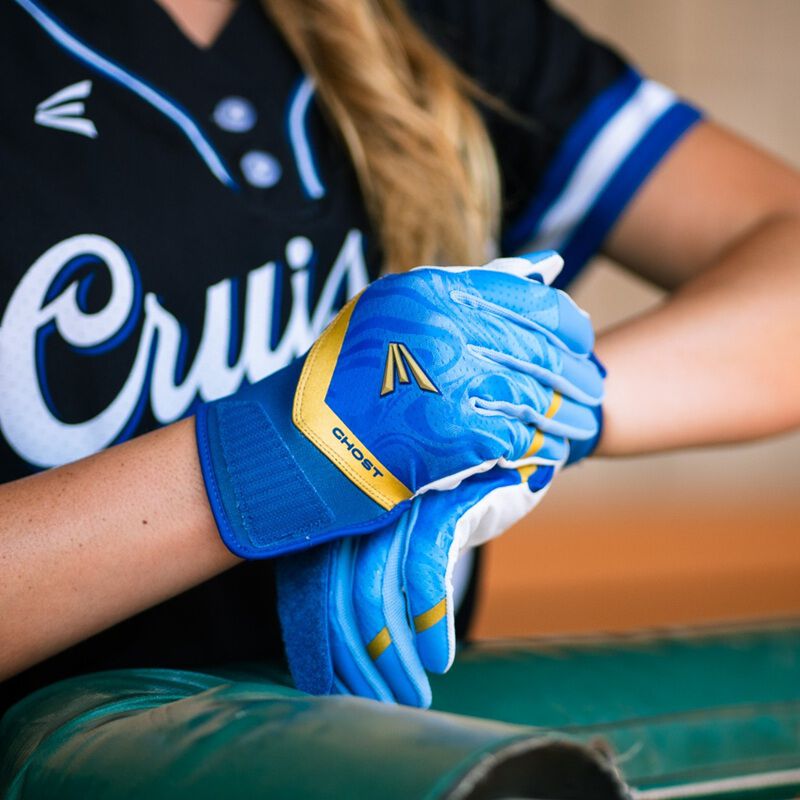 Picture of a player wearing a blue Ghost Ethos Out of the Blue fastpitch batting glove and strapping the other