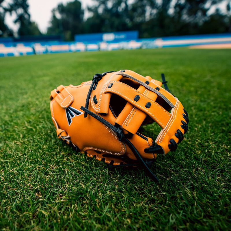 Picture of a tan Professional Collection Color Splash 34" catcher's mitt on a field