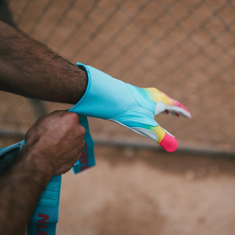 A player pulling an Eason Walk-Off Ethos Locked-In Fire batting glove on his hand loading=