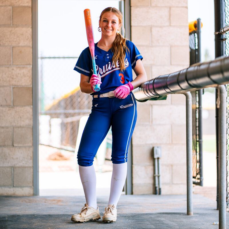 Picture of a player standing in the dugout with an Easton Ghost OG Rainbow sherbet fastpitch bat