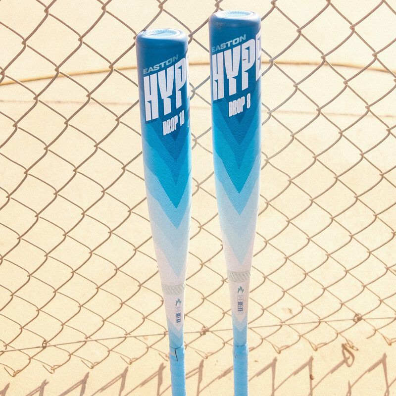 A picture of 2 Hype Fire Arctic Flame USSSA bats leaning against a fence