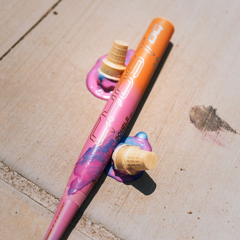 Barrel of an Easton Ghost OG Rainbow sherbet fastpitch bat on sidewalk with two scoops of melted sherbet by it