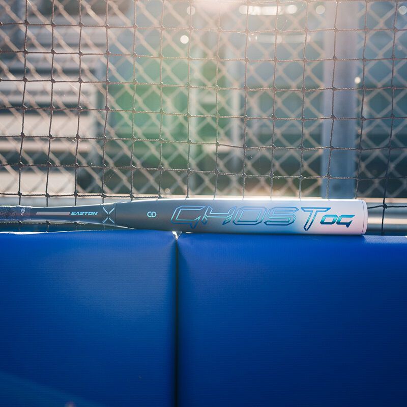Picture of a 2025 Easton Ghost OG fastpitch bat on top of a backstop padding