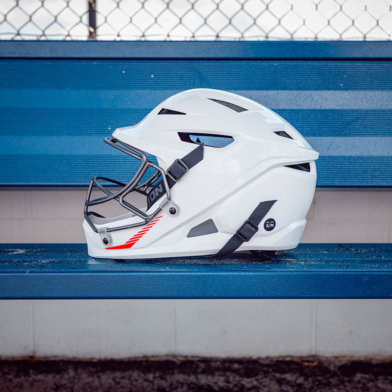 Left side of a white Easton Hellcat fielding helmet sitting on a dugout bench - SKU: EHCATH loading=
